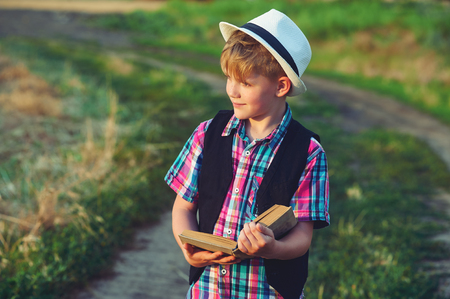 boy reading a book in the field .The concept of children's educationの写真素材