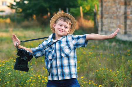 A little boy with an old camera .Young cheerful photographerの写真素材