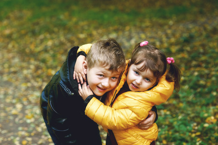 Brother and sister hugging in an autumn Park