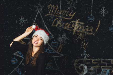 Portrait of a young woman in a cap of Santa Claus on Christmas background . Merry Christmasの写真素材
