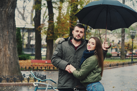 Young loving couple on a city street . Romantic couple in autumn city walkの写真素材