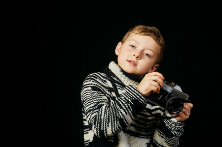 Beautiful boy with camera in Studio on dark backgroundの写真素材