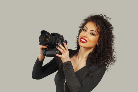 Young woman photographer holding a digital camera