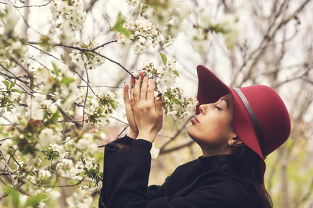 Portrait of a young woman in a blossoming spring gardenの写真素材