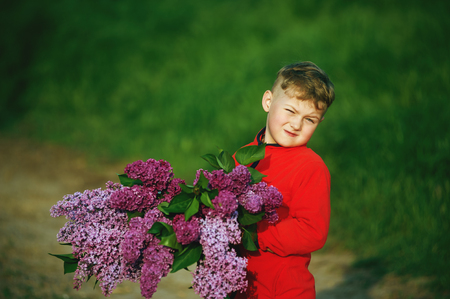 A boy with a bouquet of lilacsの写真素材
