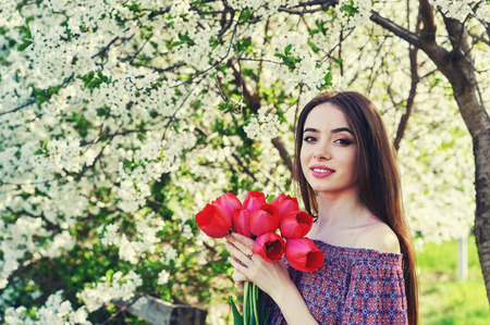 young woman with tulips in a blossoming Parkの写真素材