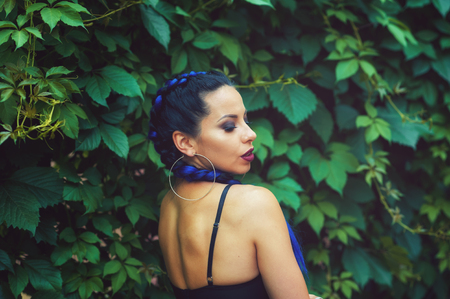 Portrait of a young woman with braids on a green backgroundの写真素材