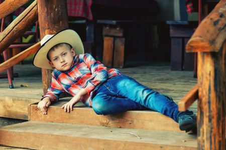 Portrait of a boy in a stylish hat in a stylized street cafeの写真素材