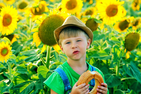 Cheerful boy with a loaf of bread in natureの写真素材