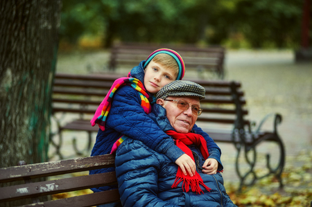 Grandson and grandfather on a walk in the autumn Park. Family valueの写真素材
