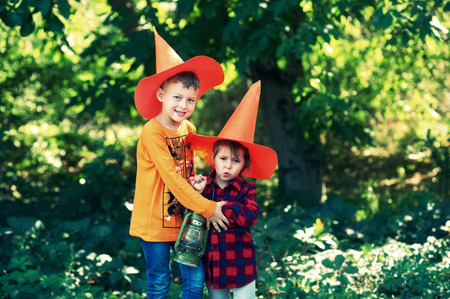 Funny kids in hats for Halloween outdoors. The day of the feast of Halloweenの写真素材