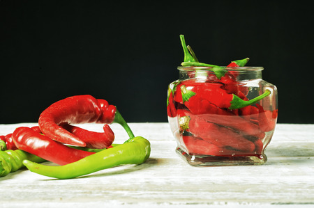Marinated hot chili pepper in a glass jar. Home blanksの写真素材