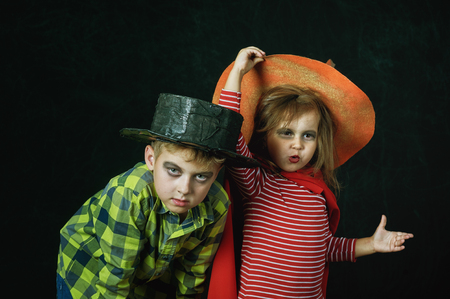 brother and sister on Halloween. Funny kids in carnival costumes on dark background .の写真素材