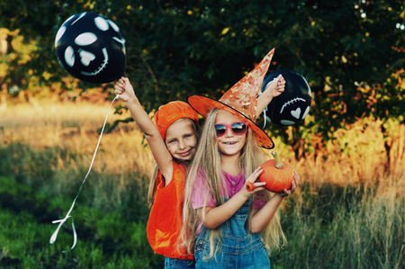 Halloween . Funny kids in with pumpkins in natureの写真素材
