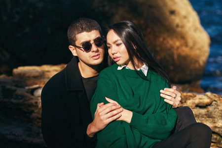 Fashionable young couple on the rocks .Young couple in love at the seaside on autumn day