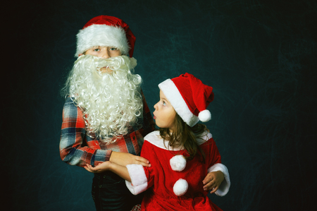 funny brother and sister in Christmas costumes on dark background . Children waiting for Christmasの写真素材