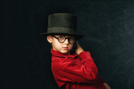 portrait of a boy close-up on a dark background . Child in red stylish shirtの写真素材
