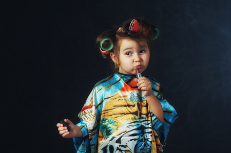 Portrait of a little fashionable girl in curlers. The concept of femininityの写真素材