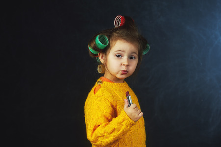 Portrait of a little fashionable girl in curlers. The concept of femininityの写真素材