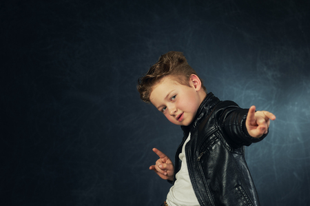 Studio portrait of a stylish boy in a leather jacket . Little rockerの写真素材