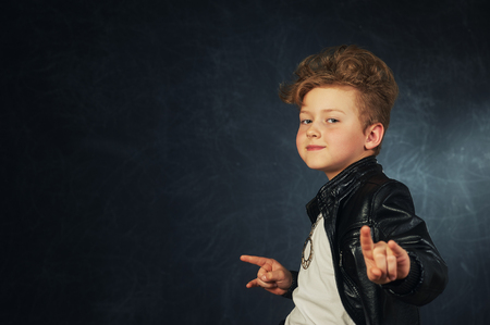 Studio portrait of a stylish boy in a leather jacket . Little rockerの写真素材