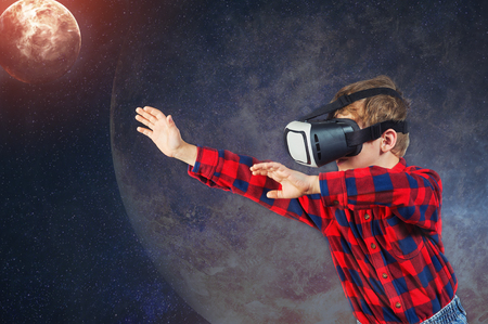 Virtual world of technology. A child plays in a virtual realityの写真素材