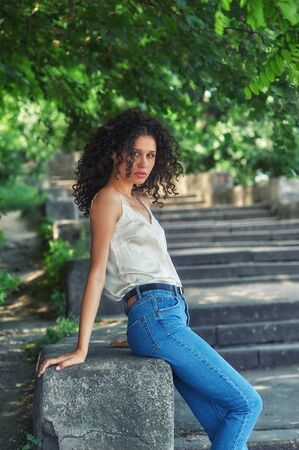 Portrait of a young girl in the city . Slim model in jeans and light blouseの写真素材