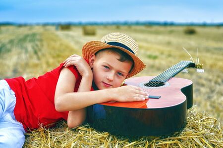 Portrait of a little boy on vacation in the field . The child lying in the mangerの写真素材