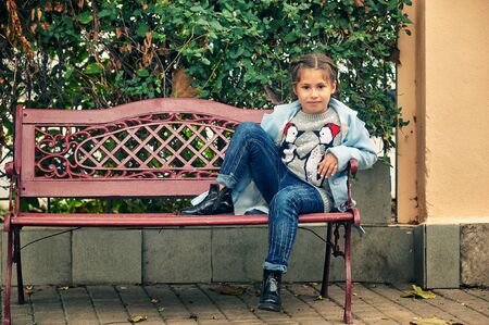 Portrait of a little girl on an autumn day . The child wears a coat .の写真素材