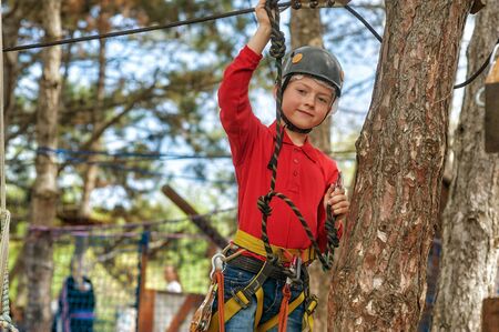 Boy in climbing equipment, active children's outdoor recreationの写真素材