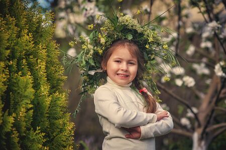 Portrait of a little girl on a walk . The child wears a wreath of field herbs on his head .の写真素材