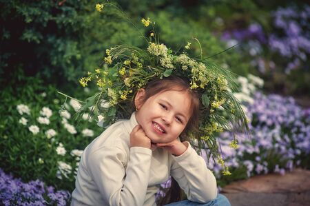 Portrait of a little girl on a walk . The child wears a wreath of field herbs on his head .の写真素材