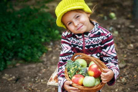 Portrait of a happy little girl with a crop of apples. Home gardeningの写真素材