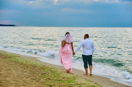 A married couple on the beach at dawn on their wedding anniversaryの写真素材