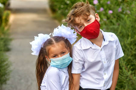 Portrait of children in medical masks. Brother and sister go to school in protective masks.の写真素材