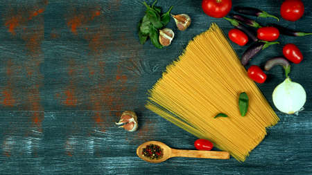 Ingredients for cooking spaghetti on a dark background. There is space for text
