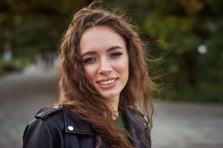 Portrait of a young beautiful girl in a leather jacket in the cityの写真素材