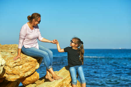 Mother and daughter on the sea coast on an autumn dayの写真素材