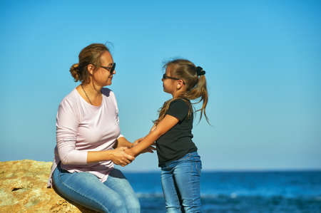 Mother and daughter on the sea coast on an autumn dayの写真素材