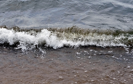 oncoming wave gives a lot of spray, the lake is cloudy