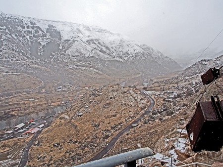view of the Kura river valley from Vardzia monastery during spring snow and fog, right cable box for lifting loads from belowの写真素材