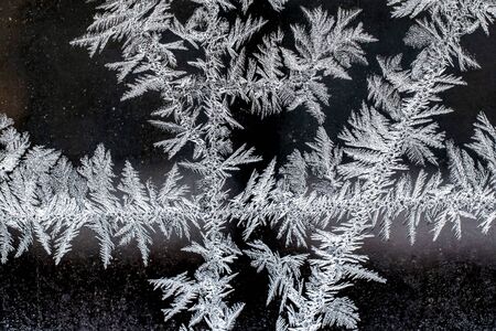 Frosty natural pattern on a winter window, texture of frosty patterns, dendritic image structureの写真素材