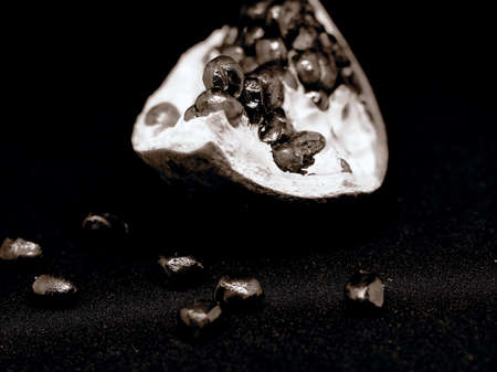 slice the pomegranate with red grains on a black background, a narrow focus areaの写真素材