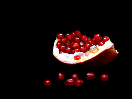 slice the pomegranate with red grains on a black background, a narrow focus areaの写真素材
