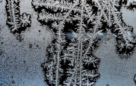 fantastic frost pattern on the winter window, texture of frost patterns, dendritic structure of the...