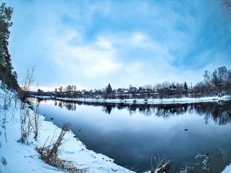 view of pine trees growing on the rocky and steep bank of the Miass river in winter, snow-covered banks, forest, countryside, Chelyabinsk, Kashtak, Southern Urals, fisheye lensの写真素材
