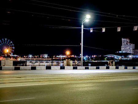 deserted illuminated night road in the city, bridge over the river, Chelyabinsk, Russiaの写真素材