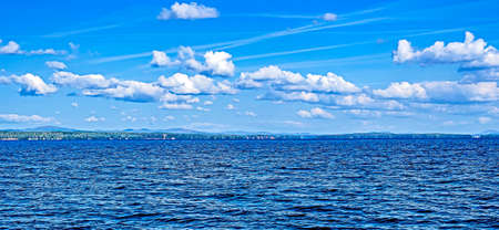 panorama blue sky with white cumulus clouds over morning lake, southern Urals, Lake Uvildy