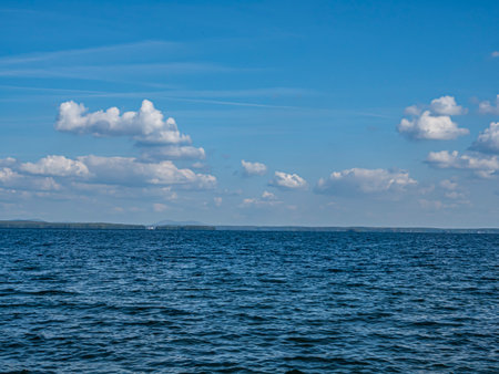 panorama blue sky with white cumulus clouds over morning lake, southern Urals, Lake Uvildyの写真素材