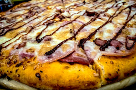 fresh pizza on the table on a wooden platter, macro